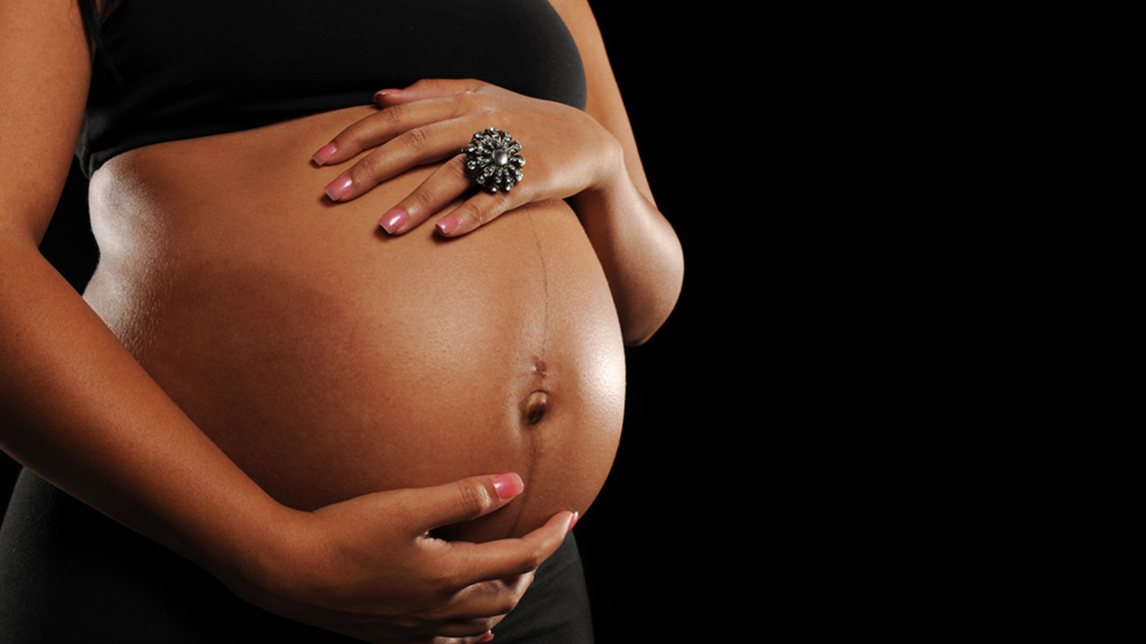 African American Woman pregnant against a black background; Shutterstock ID 60729988; PO: KTRK